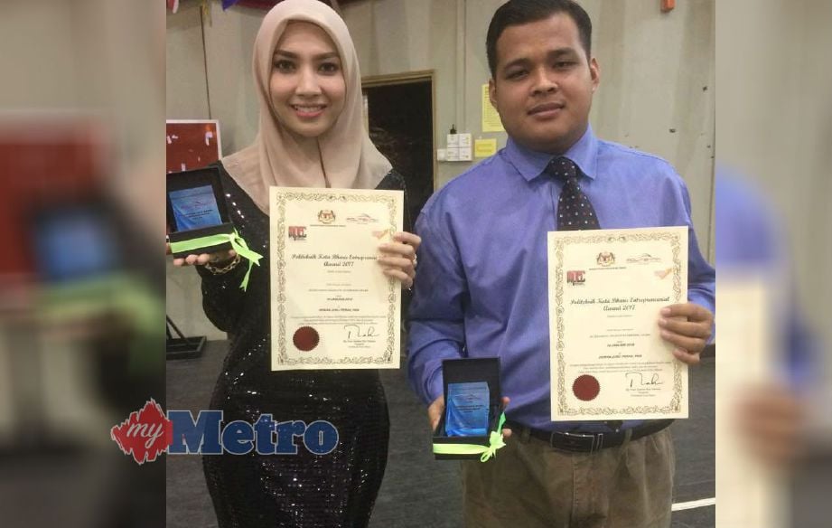 NIK Amirah Syahmimi (kiri) bersama Mohd Azreen Shahiran (kanan) menunjukkan sijil penghargaan dan plak yang diterima selepas Majlis Anugerah Keusahawanan Politeknik Kota Bharu (PKB) 2017. Gambar Hazira Ahmad Zaidi.